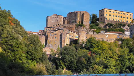 Panning-shot-of-Pitigliano-Village-with-old-buildings-located-on-Hill-during-sunny-day-in-Tuscany,Italy