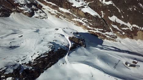 Pista-De-Esquí-En-Los-Alpes-Suizos-Que-Cruza-Una-Gran-Roca