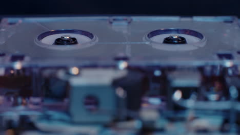 Microcassette-Recorder-Reels-In-Motion-With-Exposed-Internal-Components-Visible-In-Foreground-Under-Cold-Blue-Lighting
