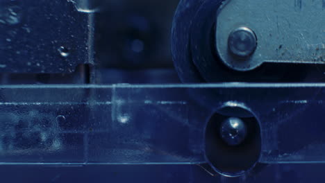 Extreme-Close-Up-Of-Microcassette-Pinch-Roller-Spinning-In-Cold-Blue-Light