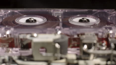 Microcassette-Recorder-Reels-In-Motion-With-Exposed-Internal-Components-Visible-In-Foreground