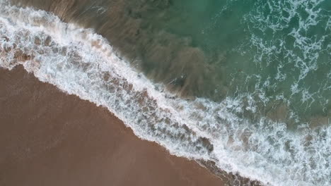 Topdown-View-Of-Foamy-Breaking-Waves-From-Turquoise-Ocean