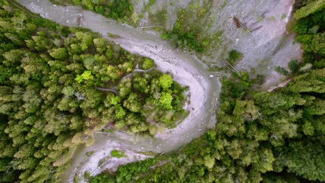 Rocky-Eroded-River-bank-with-steep-cliff-meandering-forest-landscape-view-from-above