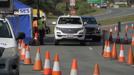 Polizist-Am-Checkpoint-Hilft-Und-Spricht-Mit-Einem-Fahrer-In-Einem-Auto---Nsw-qld-Staatsgrenze---Coronavirus-pandemiebeschränkungen-In-Australien
