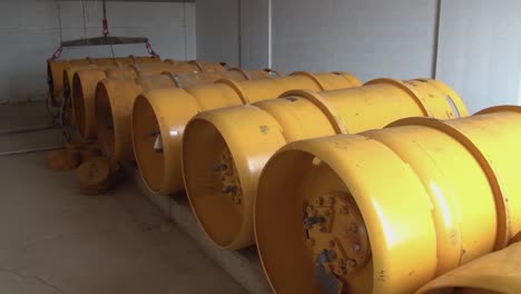 High-angle-shot-of-yellow-plastic-water-storage-tanks-in-a-waste-water-treatment-facility-inside-a-room-at-daytime