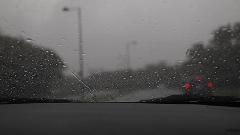 Auto-Fährt-Bei-Regen-Auf-Der-Autobahn,-Weitschuss-Mit-Verschwommenem-Hintergrund,-Windschutzscheibe-Bei-Regen