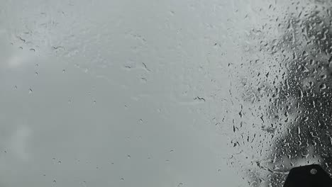 view-from-below-inside-a-car-in-the-rain,-raindrops-falling-on-the-windshield