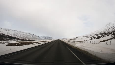 Breiter-Pov,-Der-Im-Winter-Auf-Einer-Verschneiten-Isländischen-Straße-Fährt---Kopierraum-Im-Himmel