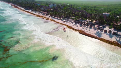 Aerial-Drone-View-of-Kids-Flying-Parafoil-Beach-Kite-In-Tropical-Caribbean-Beach