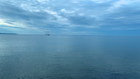 Lonely-ship-on-calm-sea,-small-waves-and-clear-blue-water,-Baltic-Sea-in-Poland-Rewa