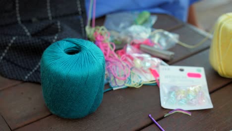 Overview-of-yellow-and-blue-yarn-ball-been-used-to-make-friendship-bands-and-necklace-for-supporting-the-Ukrainian-refugees-over-a-table-at-daytime