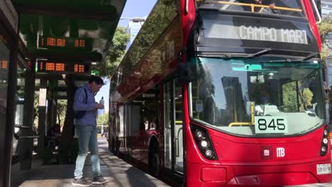 Autobús-Rojo-De-Pasajeros-Que-Llega-A-Una-Estación-En-La-Avenida-Paseo-De-La-Reforma,-Ciudad-De-México