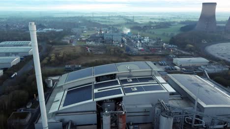 Futuristic-solar-green-energy-factory-rooftop-on-foggy-rural-countryside-morning-aerial-view-close-up-to-pull-away-shot