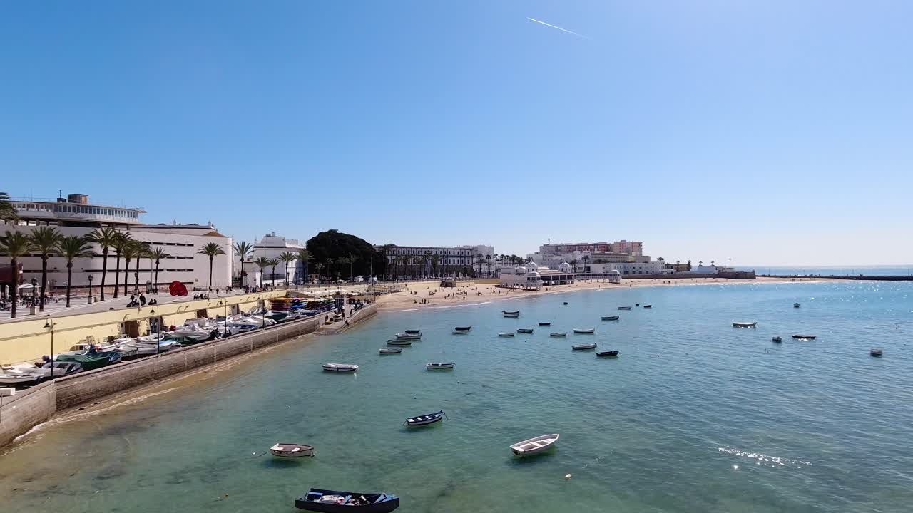 Premium stock video - Wide open view over boats in ocean in cadiz at low  tide with beach