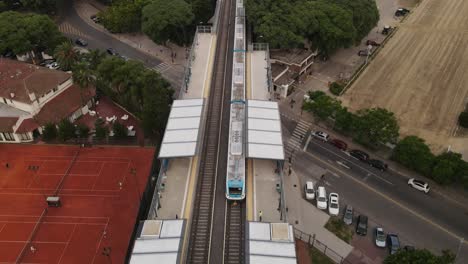 Aerial-shot-of-train-arriving-to-modern-Barrancas-de-Belgrano-station-in-Buenos-Aires-City