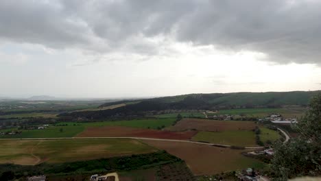 Wide-open-panoramic-view-with-clouds-over-green-landscape-with-cloudy-sky