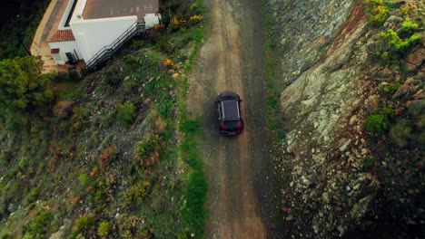 Aerial-birdseye-view-of-car-driving-on-the-dirt-roat