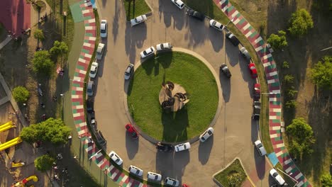 Aerial-orbit-top-view-of-roundabout-with-many-parking-and-driving-cars-in-colorful-road-during-sunset-time-in-Cordoba-City