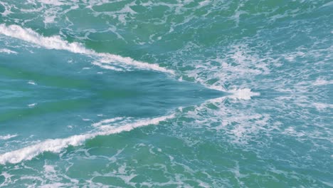 Specular-dreamy-reflection-of-turquoise-water-waves,-aerial-drone-flying-forward,-day