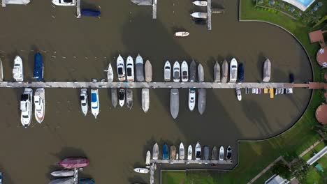 Luftdrohnenansicht-Zahlreicher-Boote,-Die-Am-Dock-Eines-Privaten-Golfclubs-Angedockt-Sind