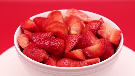 Rotating-fresh-strawberry-isolated-on-red-background