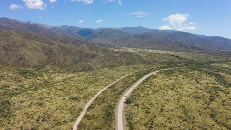 Dos-Vehículos-Desde-Lejos-Viajando-Por-Un-Camino-Solitario-A-Través-Del-árido-Valle-De-Mendoza