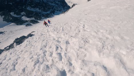 Alpinists-hiking-down-a-steep-snowy-mountain's-slope---GoPro-Head-View
