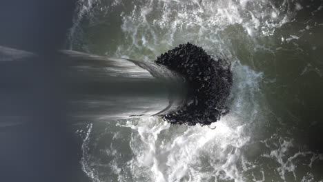 Looking-over-an-ocean-pier-and-down-one-of-the-supports-at-barnacles-at-the-waterline