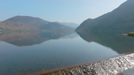 ENNERDALE-WATER-Lake-District-Unesco-National-Park,-Aerial-early-morning-push-forward-across-lake-reservoir-dam-looking-like-infinity-pool