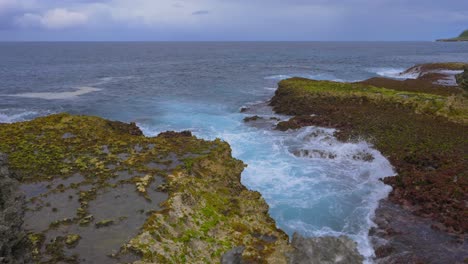 Olas-Rompiendo-En-El-Arrecife-Rocoso-Creando-Un-Hermoso-Patrón-De-Espuma-Durante-Un-Día-Nublado