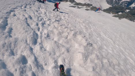 Mountaineers-in-crampons-hiking-down-a-steep-and-snowcovered-mountain---GoPro-pov-view