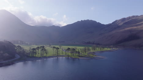 BUTTERMERE-Lake-District-Unesco-National-Park,-Aerial-Sunrise-push-forward-and-elevate-over-lake-towards-lake-head-and-mountains