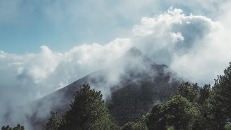 Massive-cloudscape-rolling-over-Fuego-volcano-peak-in-Guatemala,-time-lapse-view