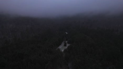 Aerial-drone-video-footage-of-nightfall-in-the-snowy-and-foggy-Appalachian-mountains-during-winter,-in-the-Catskill-Mountains-sub-range