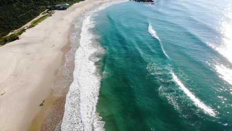 Aerial-Pan-Drone-Shot-of-People-at-Sea-and-Mountains-in-Summer-Brazil,-Florianopolis