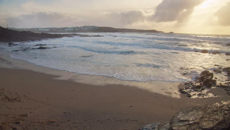 Foamy-Waves-Splashing-On-The-Shore-At-Sunset-In-Little-Fistral-Beach,-Newquay,-England---wide-view