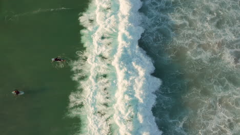 Surfistas-Divirtiéndose-En-La-Playa-De-Llandudno,-Ciudad-Del-Cabo,-Sudáfrica---Vista-Aérea-De-Arriba-Hacia-Abajo