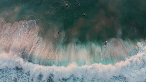 Surfers-On-The-Wave-In-Llandudno-Beach,-Cape-Town-At-Sunset---aerial-top-down