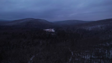 Aerial-drone-video-footage-of-a-magical,-snowy-night-in-the-Appalachian-mountains-during-winter,-in-the-Catskill-Mountains-sub-range