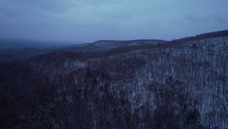 Aerial-drone-video-footage-of-nightfall-in-the-snowy-Appalachian-mountains-during-winter,-in-the-Catskill-Mountains-sub-range