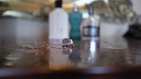 A-close-up-view-of-a-ring-on-the-dressing-table-where-as-some-water-drops-are-dropping-into-it