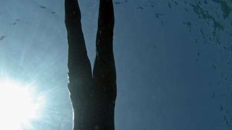 A-Man-Freediving-Under-The-Sea-On-A-Sunny-Day-In-Paralia-Emplisi,-Greece,-Europe--Underwater-Shot
