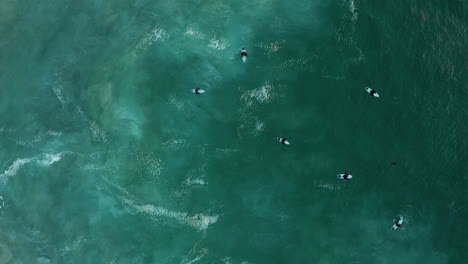 Vista-Aérea-De-Los-Surfistas-Y-El-Océano-En-Llandudno,-Ciudad-Del-Cabo,-Sudáfrica---Drone-De-Arriba-Hacia-Abajo