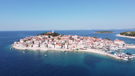 Primosten,-Dalmatia,-Croatia---Aerial-Drone-View-of-Peninsula,-Old-Town,-Port,-Beach-and-Boats