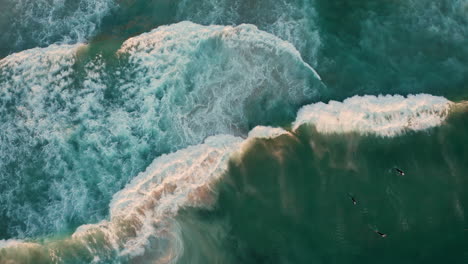 Bird's-Eye-View-Of-Surfers-At-Llandudno-Beach,-Cape-Town,-South-Africa---drone-shot
