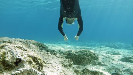 A-Diver-Swimming-Through-The-Translucent-Beach-Waters-Of-Paralia-Emplisi-During-The-Day-In-Greece,-Europe