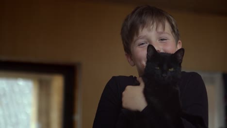 Portrait-of-a-laughing-boy-with-a-black-cat-in-his-arms
