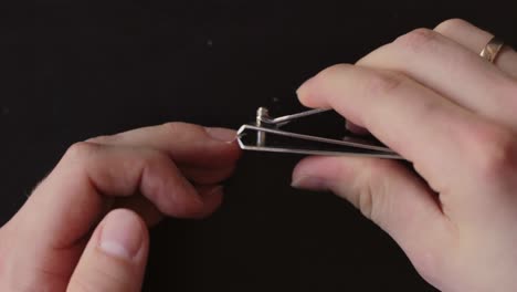 White-hands-clipping-finger-nails-with-metal-nail-clipper