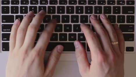 Top-down-view-of-white-man's-hands-writing-typing-on-keyboard,-static