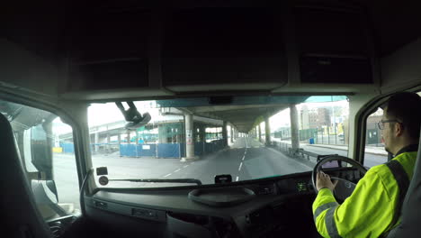 HGV-Driver-navigating-around-the-Port-Of-Dover,-UK-driving-under-an-underpass